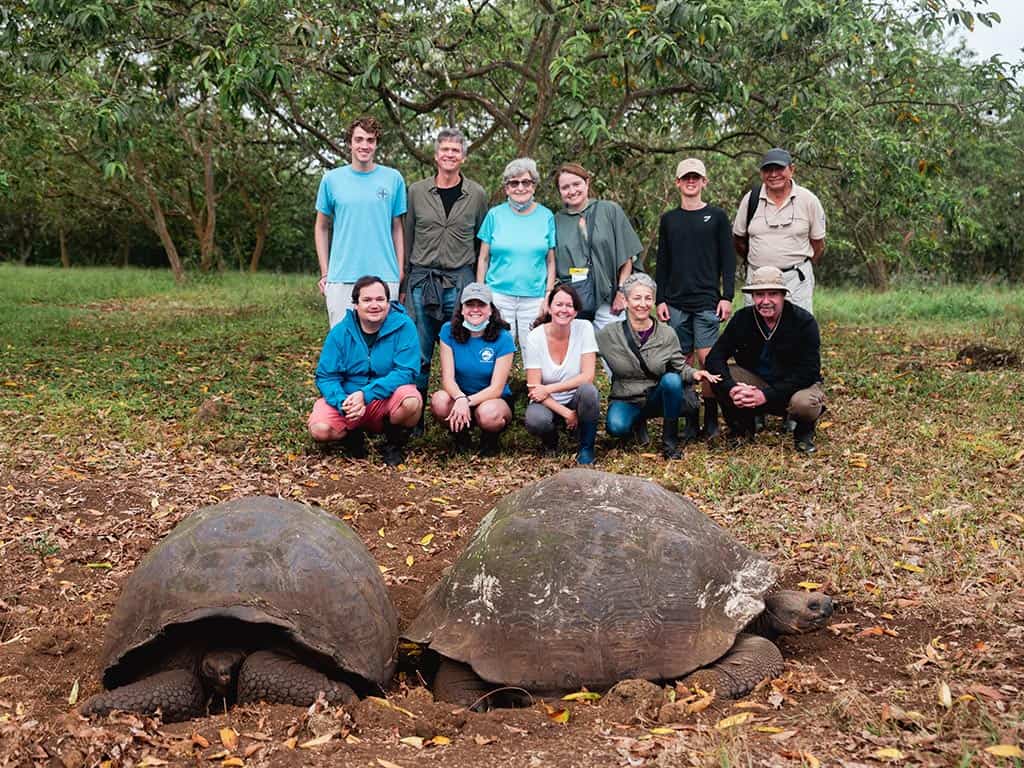 Los viajeros se fotografían con una tortuga.